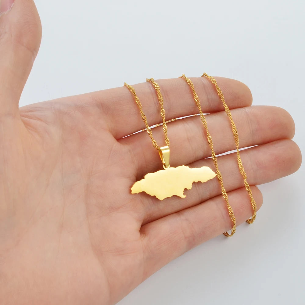 Gold necklace with a Jamaica map pendant held in a hand against a white background
